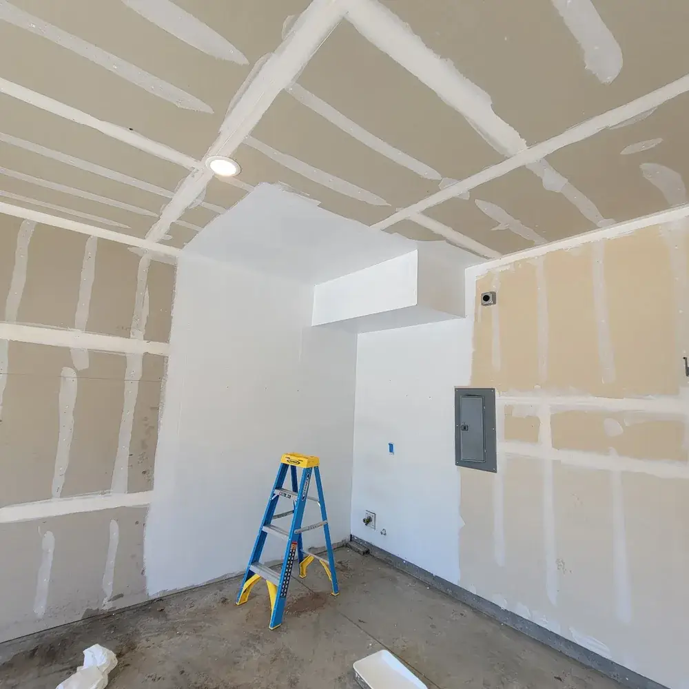 Commercial Painting in Bozeman - MT underway as a painter coats an office wall near storefront windows