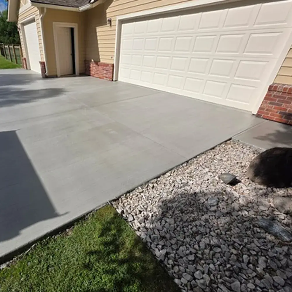 Power Washing in Bozeman - MT as a technician cleans a stained concrete driveway beside a home